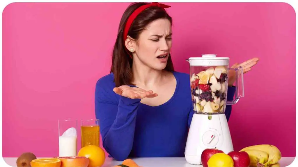 a person is standing in front of a blender with fruit and vegetables